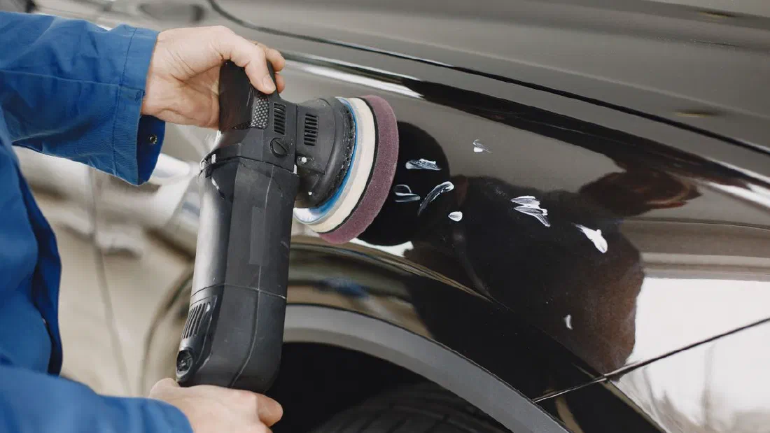 Technicien qui travaille sur une pièce de carrosserie dans un atelier à Matane